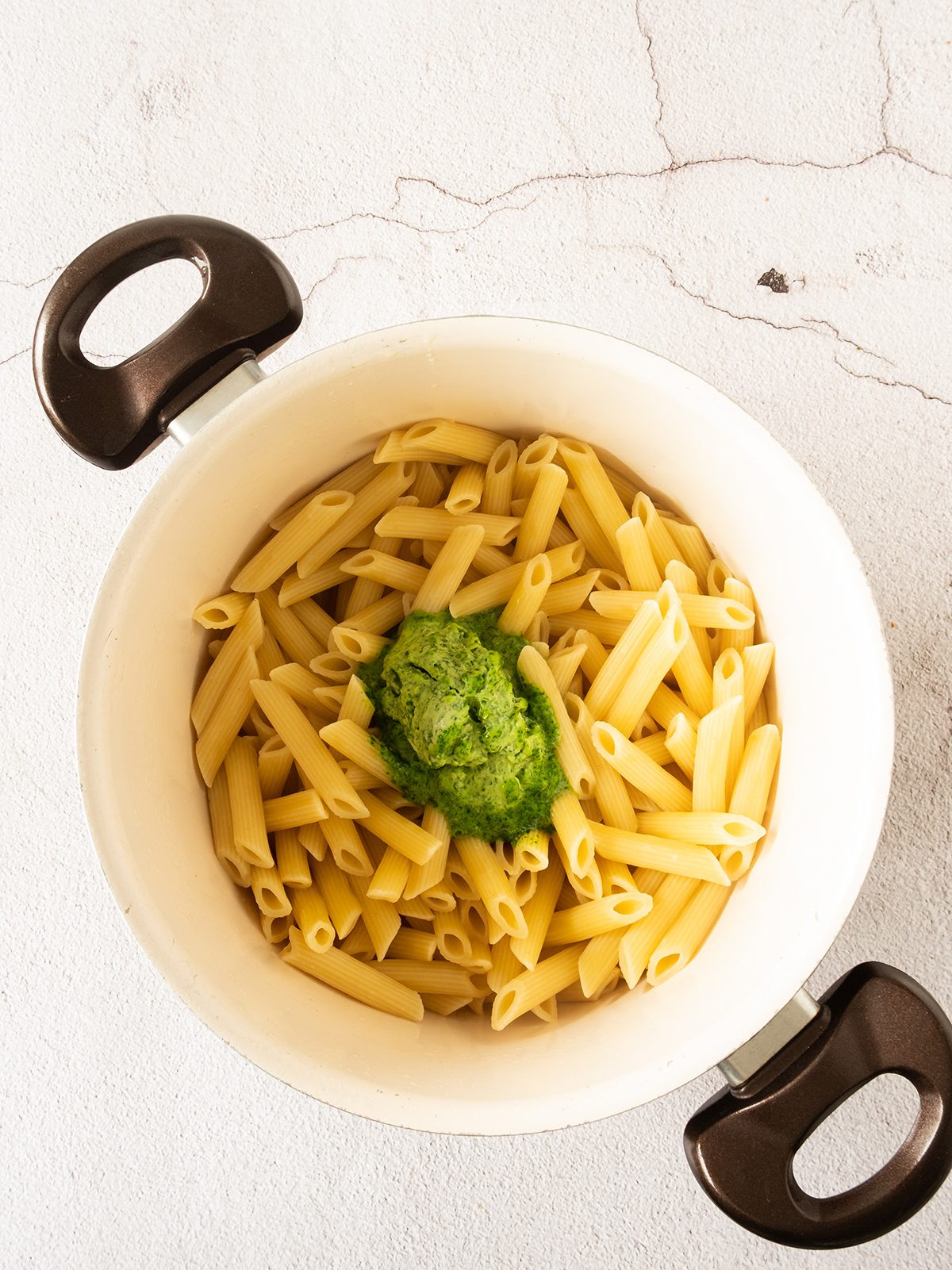 Pasta being combined with a sauce.