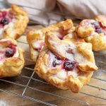 Cherry danish with puff pastry on wire rack.