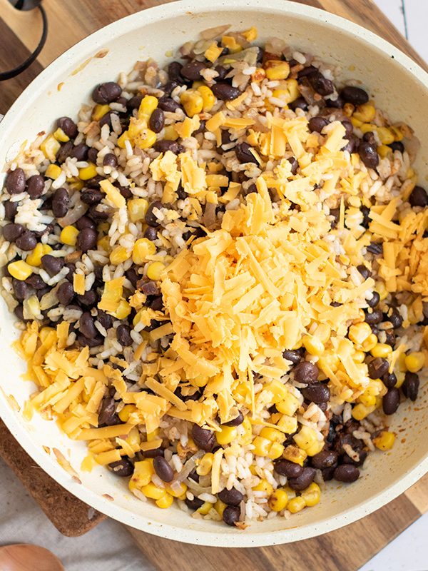 Black beans, rice, corna and cheese in a skillet.