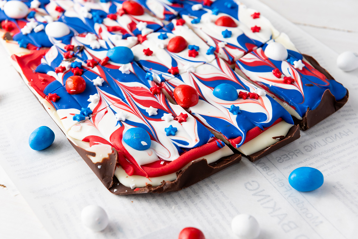 Fourth of July chocolate bark on the counter cut into square pieces.