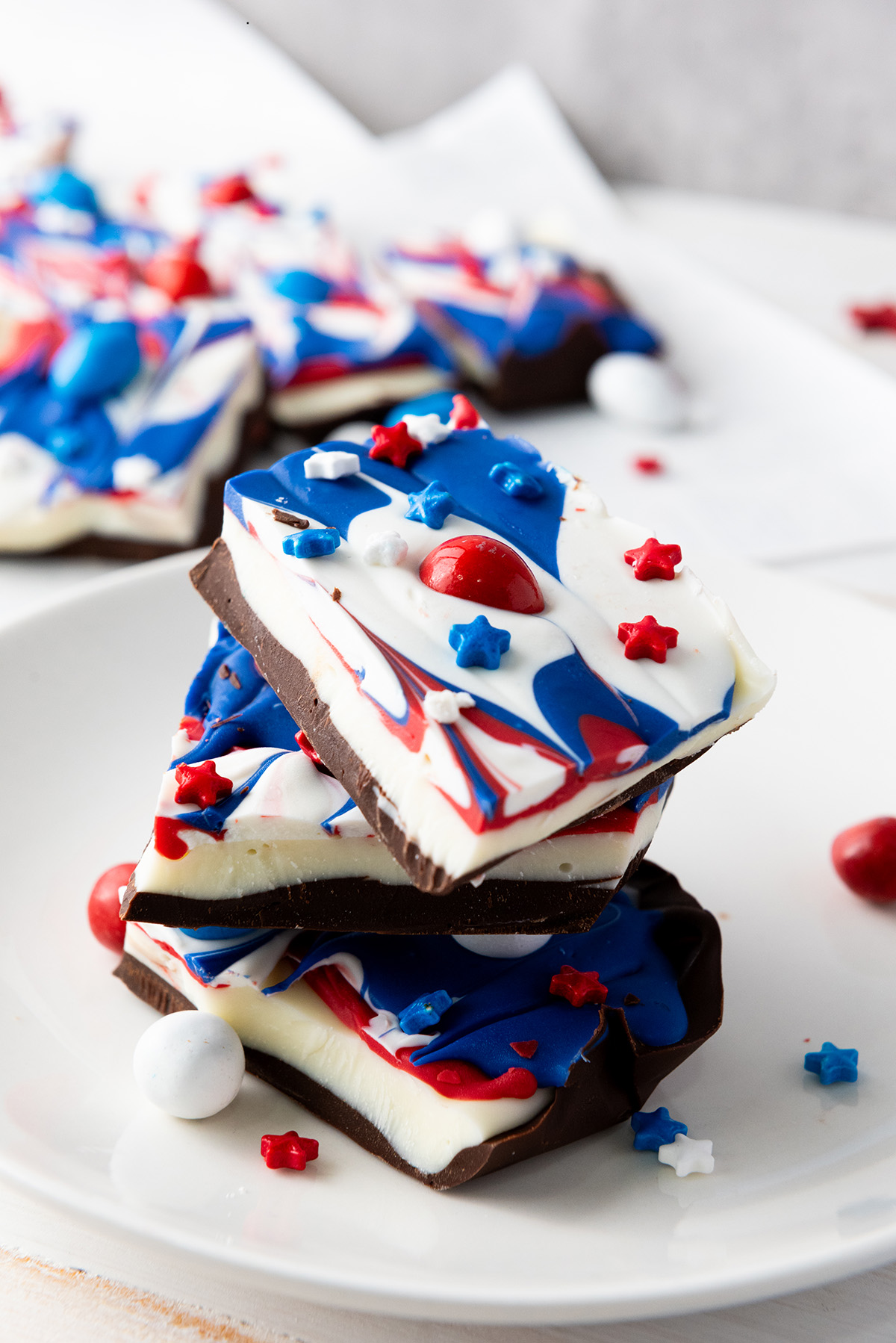 A stack of three pieces of patriotic bark with red, white and blue colors and star sprinkles.
