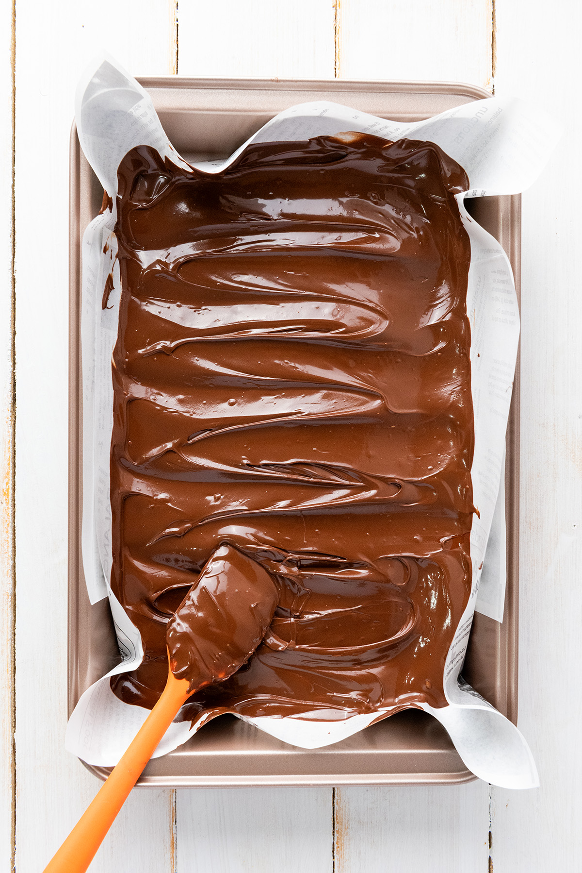 Melted chocolate being spread in a baking pan.