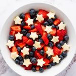 Overhead view of 4th of July fruit salad with strawberries, blueberries, and apple stars.