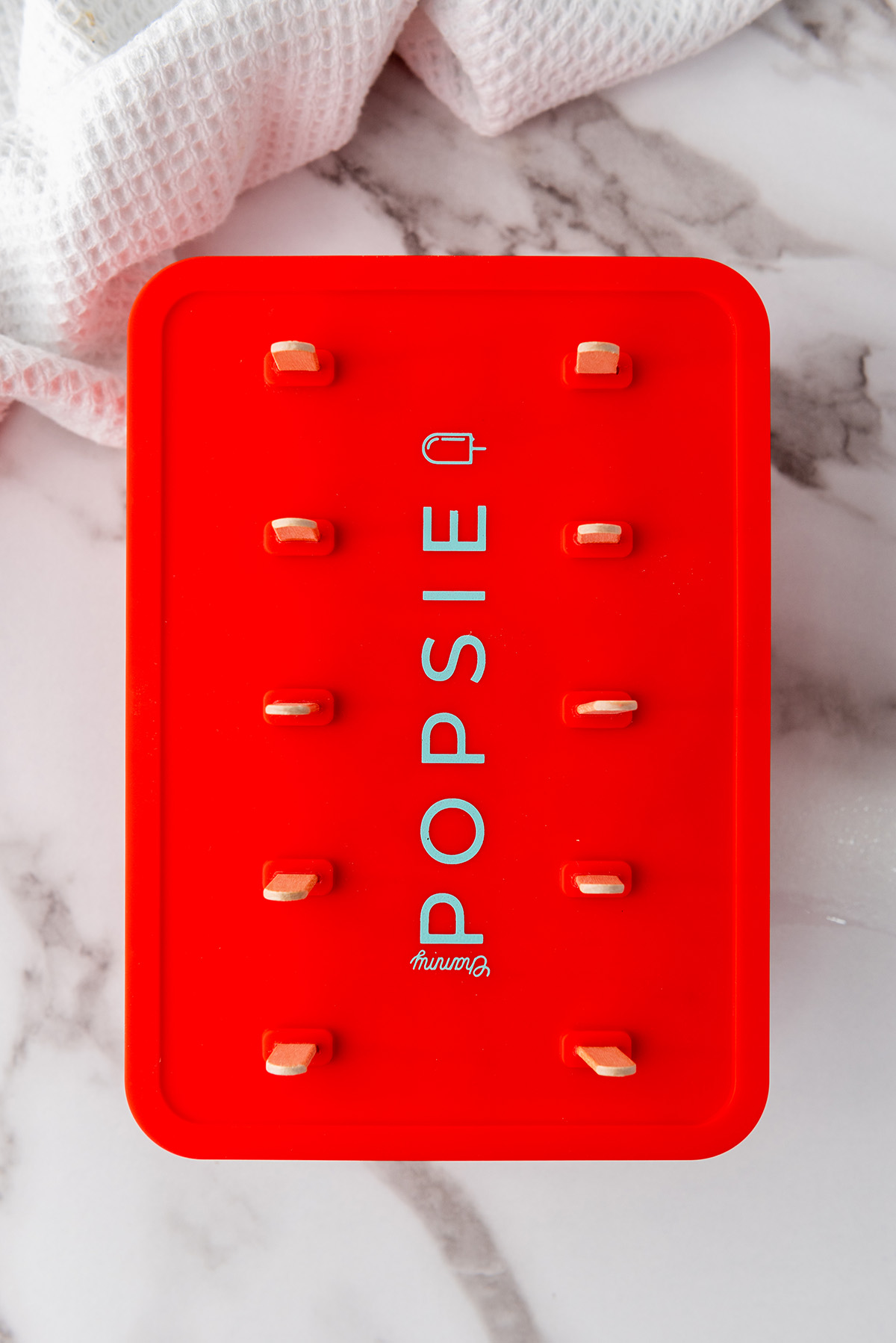 Popsicle mold filled with strawberry lemonade mixture and lid secured on top before freezing.