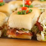 Close-up of a BLT slider showing crisp bacon, lettuce, and tomato inside a soft Hawaiian roll.