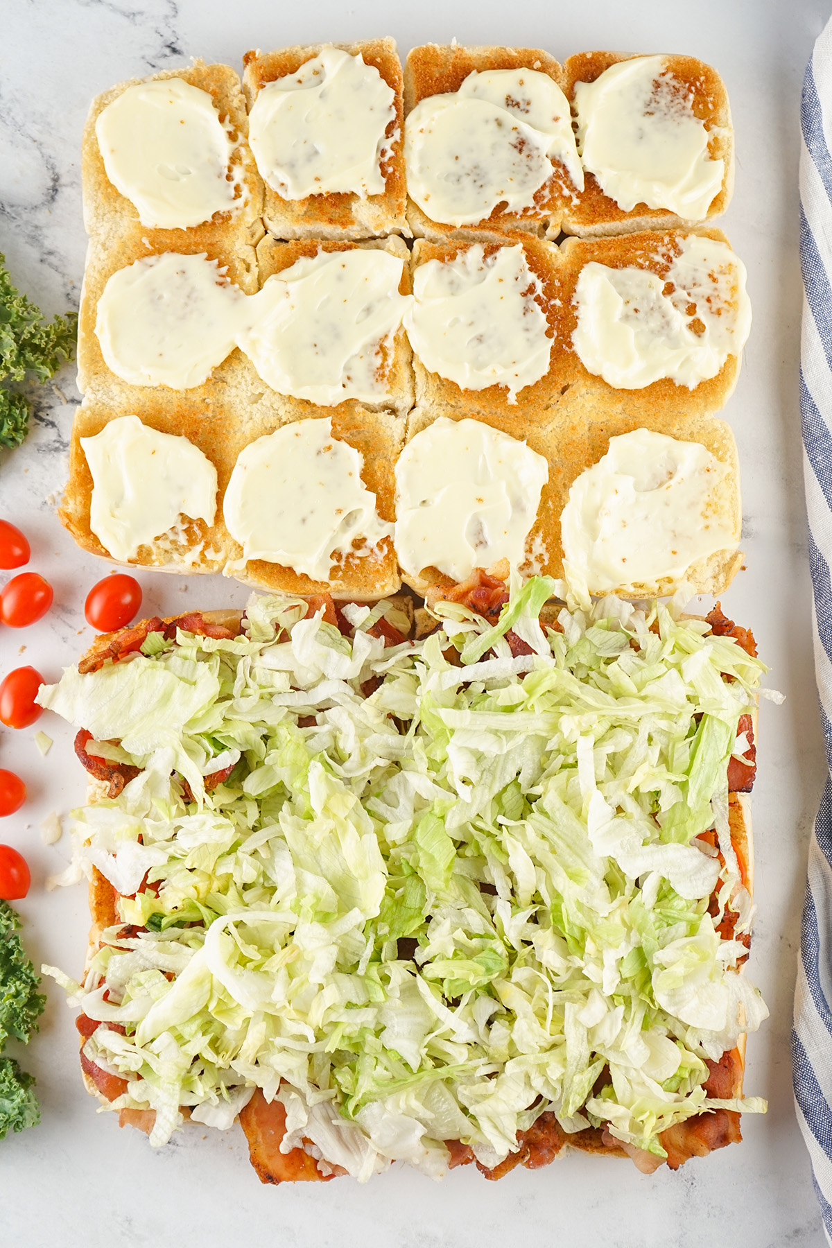 Shredded lettuce layered over bacon on the bottom half of toasted Hawaiian rolls, with mayo on the top half.