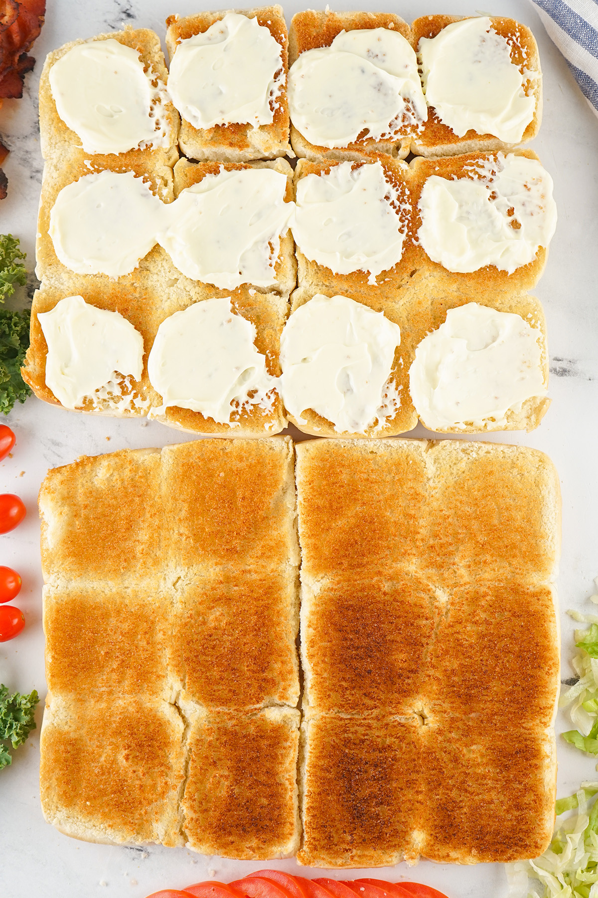 Top halves of the Hawaiian rolls toasted with mayo spread on half ready to assemble.