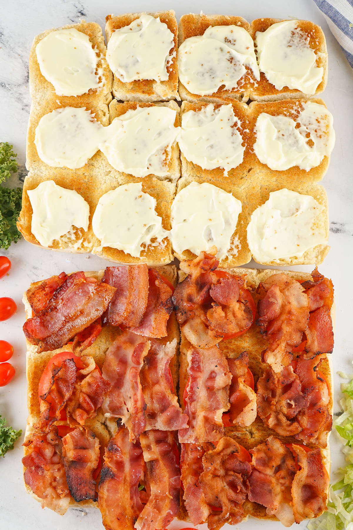 Toasted bottom halves of Hawaiian rolls spread with mayo and topped with crispy cooked bacon.