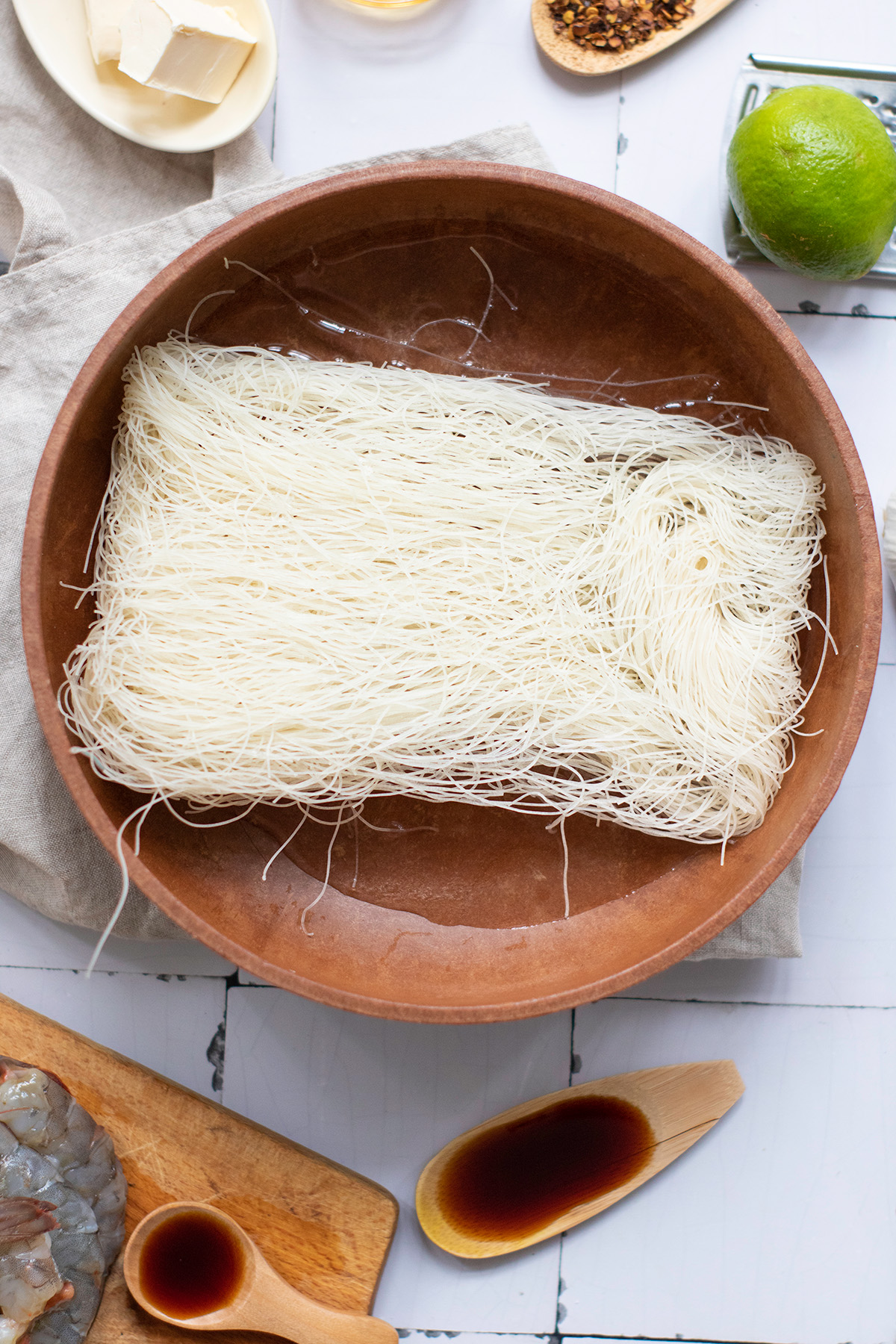 Garlic chili butter shrimp boats are quick, flavorful, and a little fancy. Juicy shrimp sit on vermicelli noodle nests that soak up every drop of the buttery garlic-chili sauce. Raw vermicelli nests soaking in warm water before assembling shrimp boats.