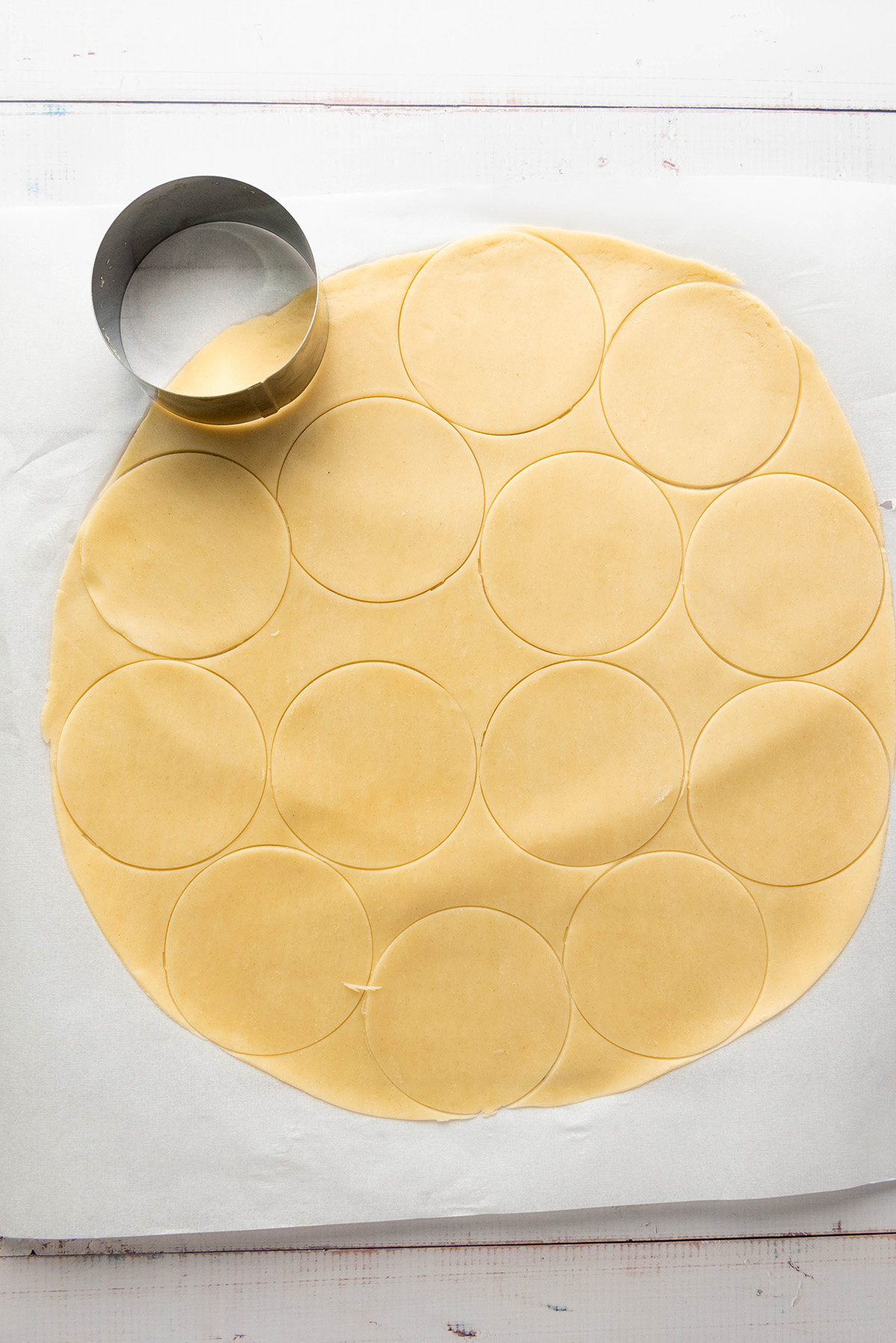 Cozy up with these easy apple hand pies made with flaky store-bought crust and a sweet cinnamon filling. All the comfort of homemade apple pie in an easy grab-and-go treat. Pie dough rolled and cut into round circles for making apple hand pies.