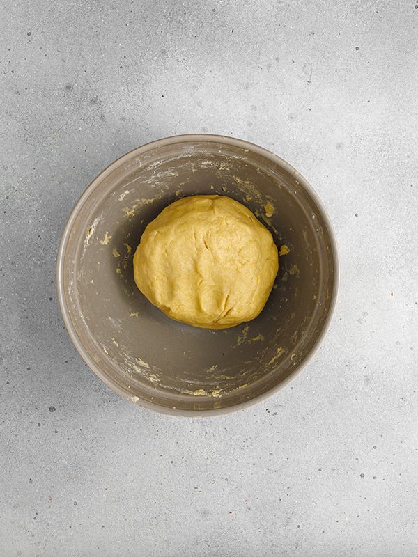 Flaky pastry, sweet caramelized onions and a creamy egg and Gruyere cheese filling make this onion tart both flavorful and irresistible to serve as an appetizer, dinner or even brunch. Smooth ball of tart dough resting in a mixing bowl after kneading.