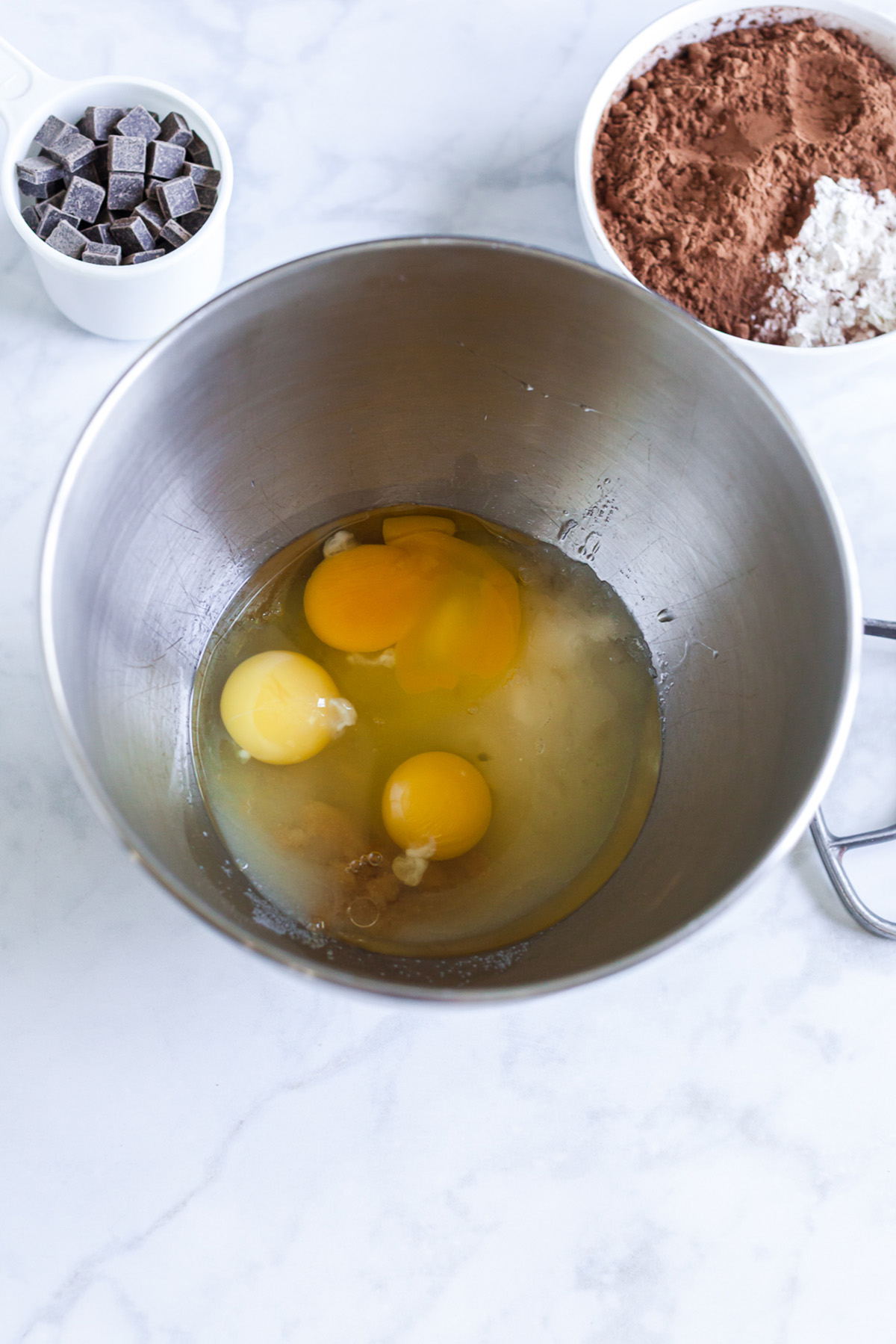 Part brownie, part cake, these brownie cakes are rich like a fudgy brownie but baked in cupcake form and made completely from scratch. Eggs, sugar, oil, and vanilla in the bowl of a stand mixer before beating.