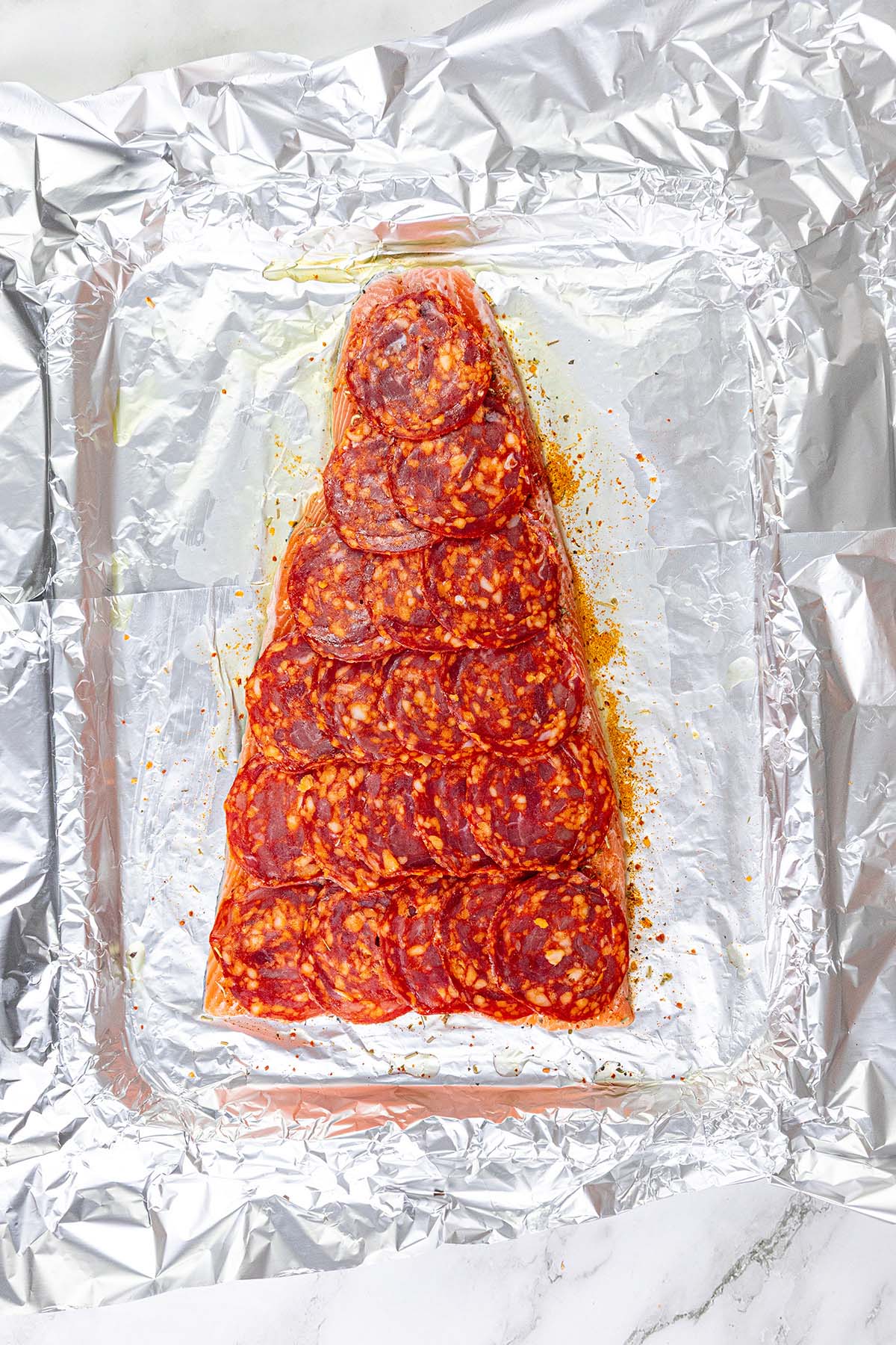 Salmon topped with chorizo slices.