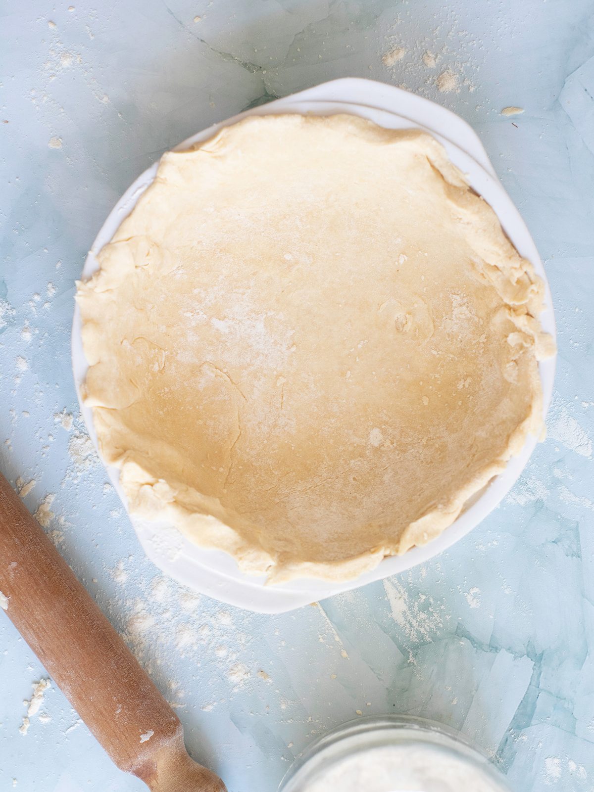 Unbaked pie crust pressed into a white pie dish, edges slightly rustic