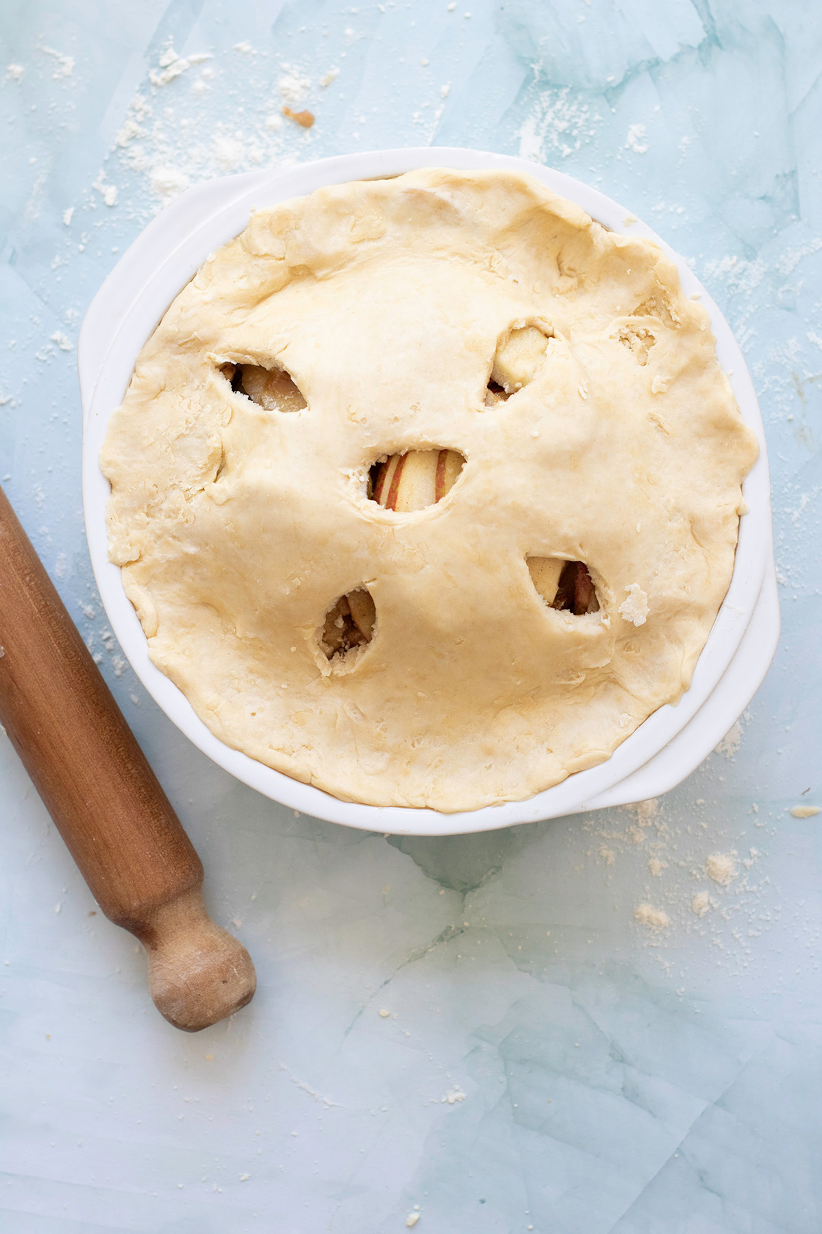 Double crust apple pie assembled with vent holes cut in the top crust