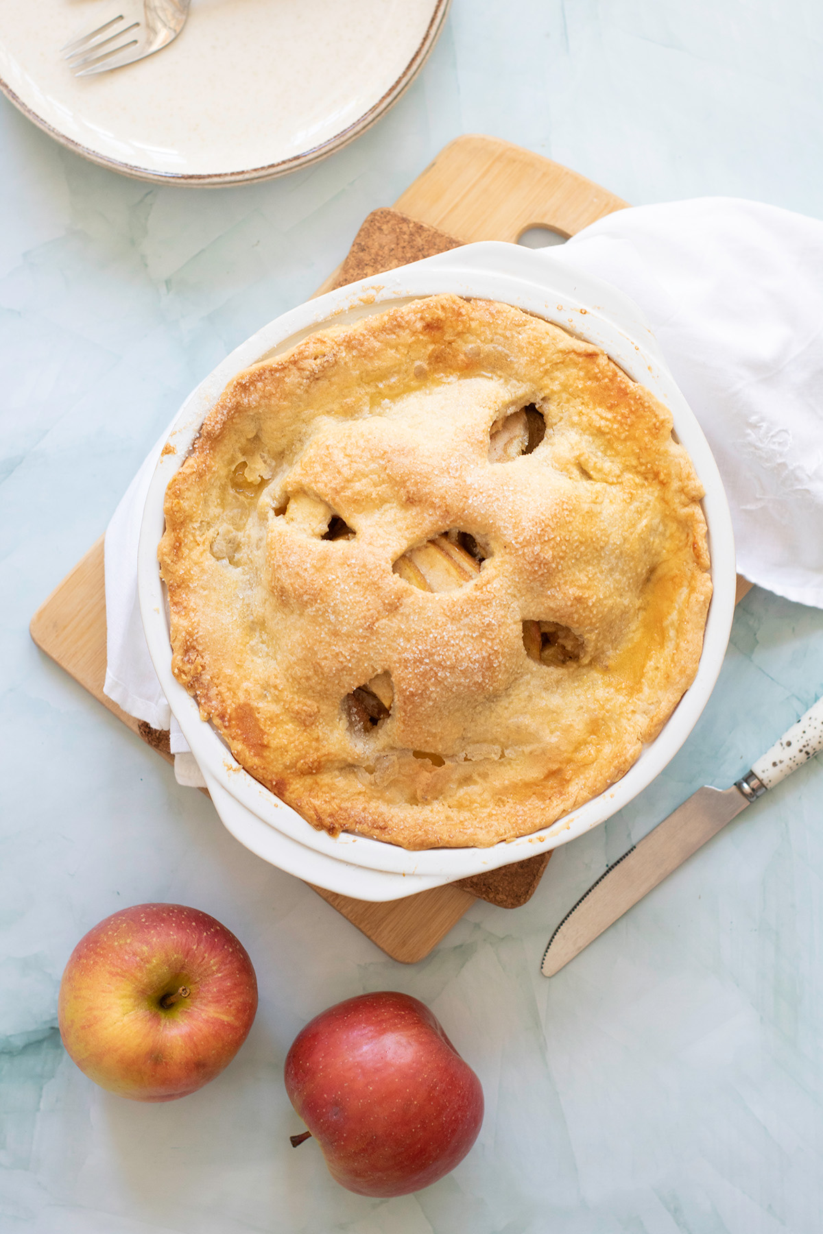 Golden baked Honeycrisp apple pie with sugar-dusted crust, cooling in dish.