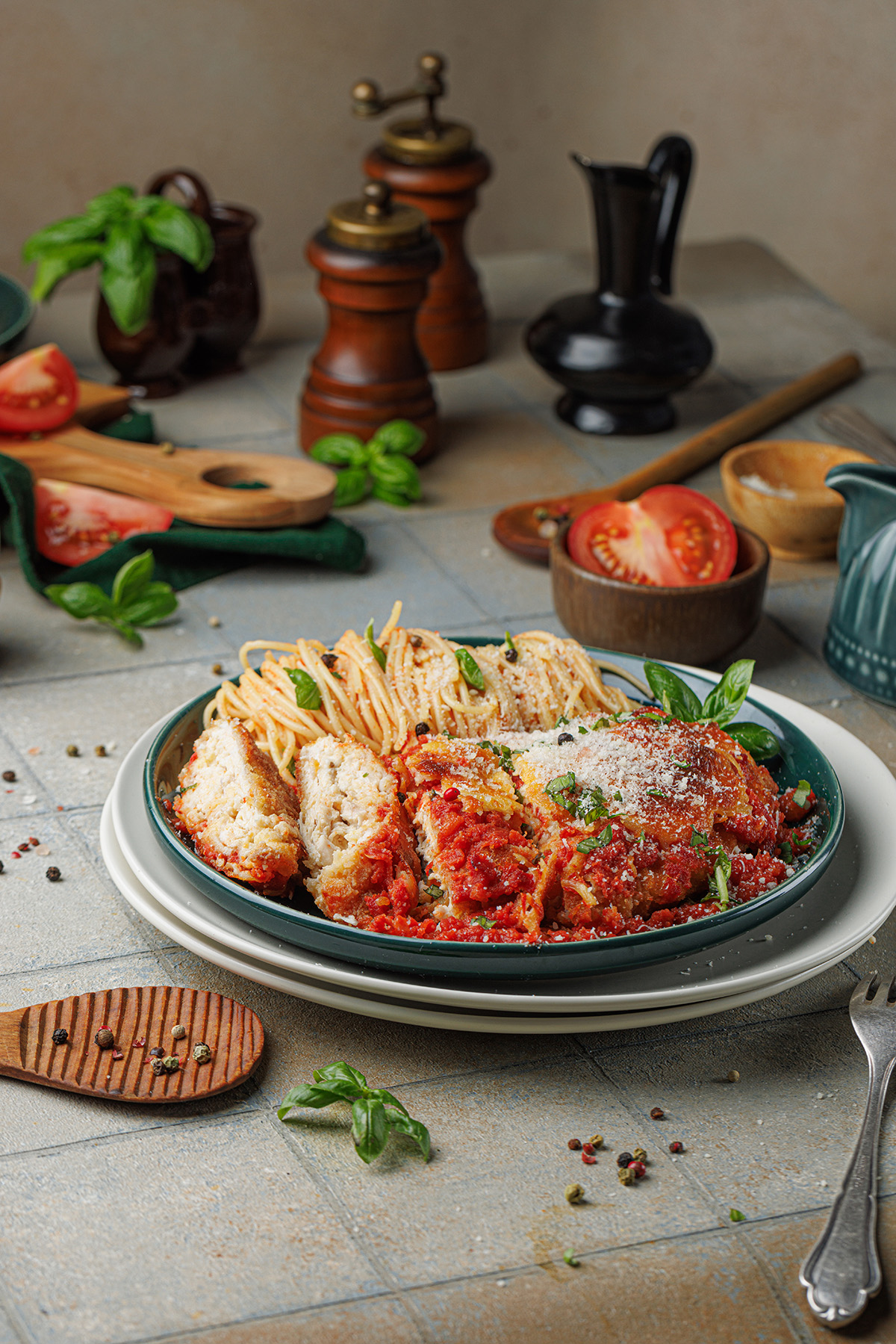 Plate of crispy chicken Parmesan topped with marinara sauce and melted mozzarella, served with spaghetti marinara and fresh basil on a rustic table.