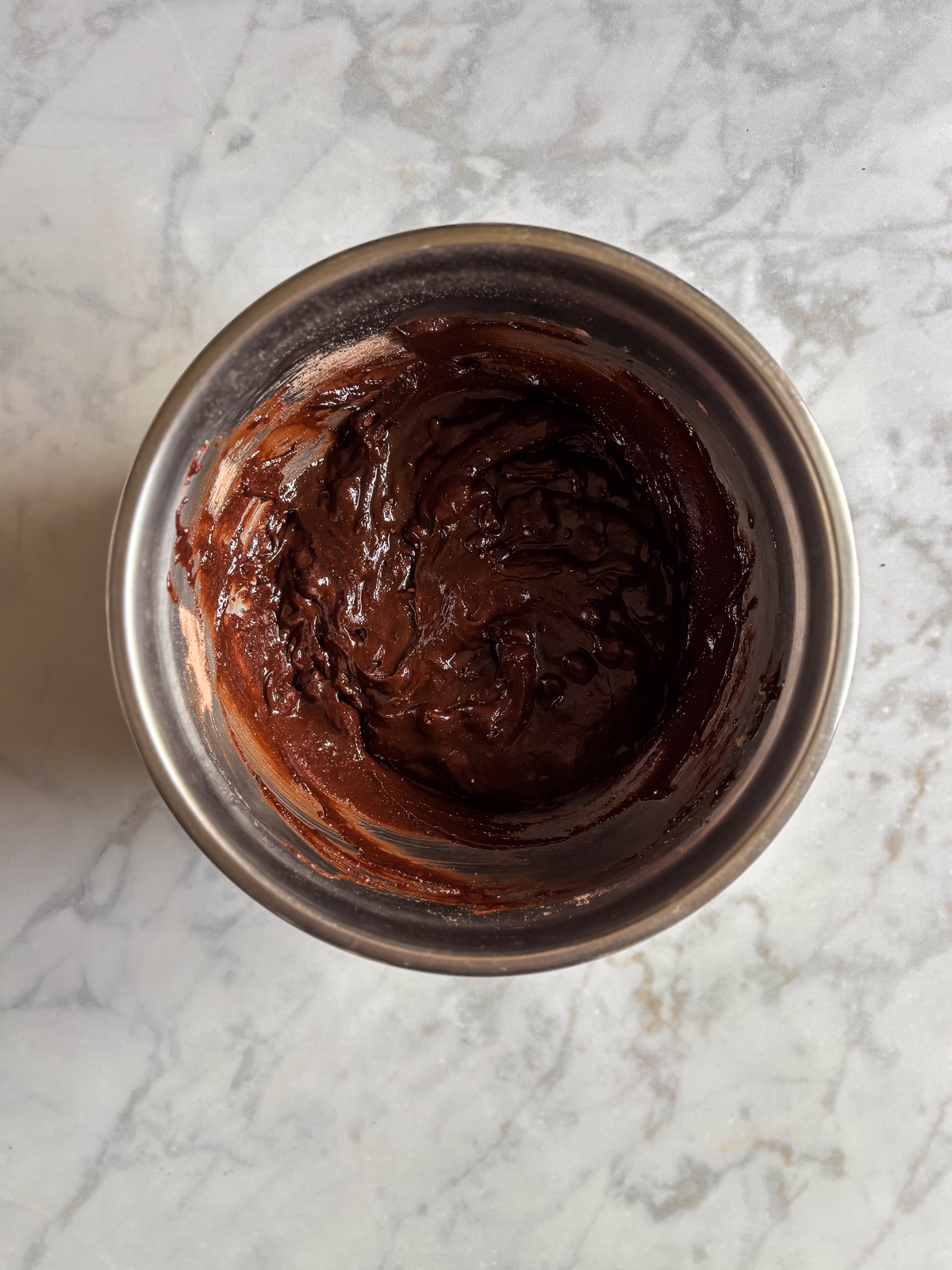 Brownie batter fully mixed together in a stainless steel bowl.