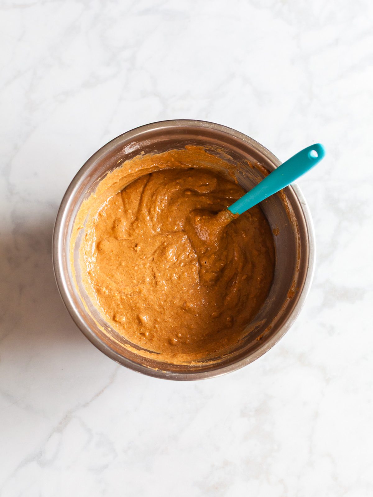 Thick pumpkin cookie batter mixed in a stainless-steel bowl for healthy pumpkin breakfast cookies.