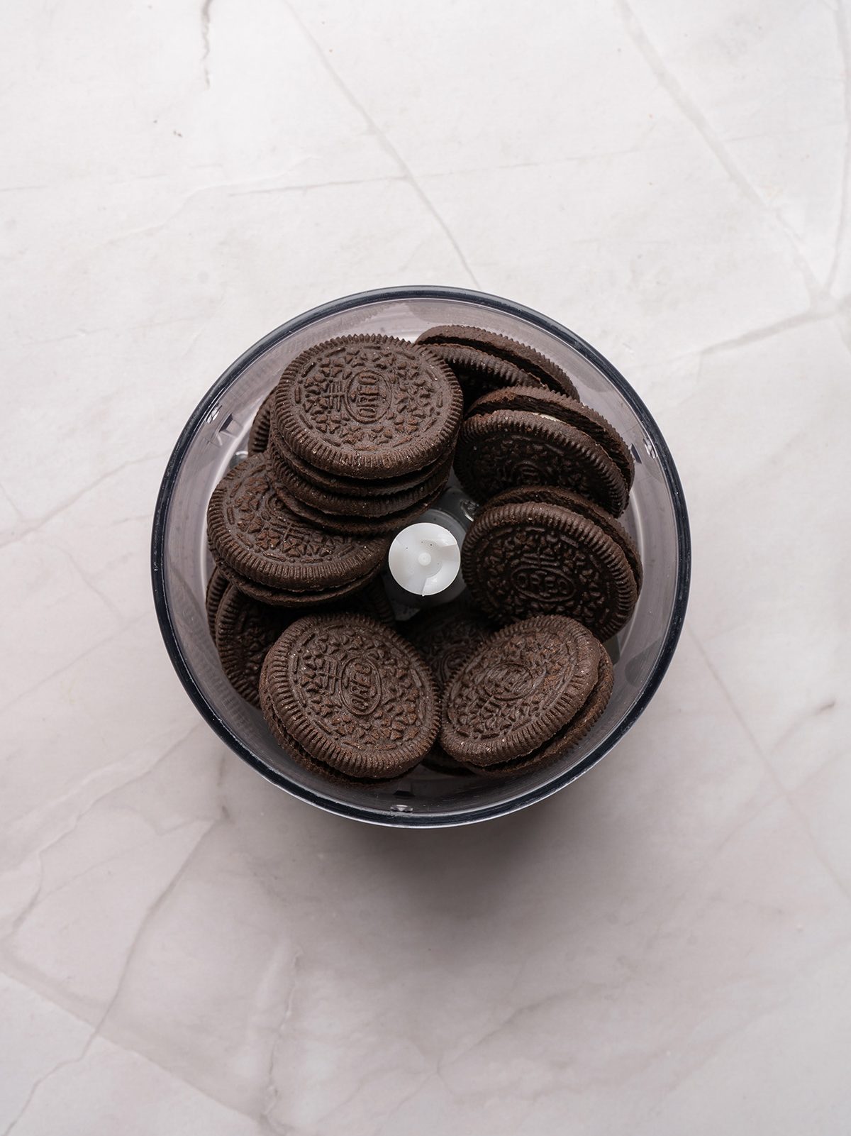 Turn classic Oreo truffles into the cutest holiday treat with these Grinch Oreo balls. They’re rich, no bake, and perfect for cookie trays, parties, and gifting. Whole Oreo cookies sitting inside a food processor bowl before being pulsed into crumbs.
