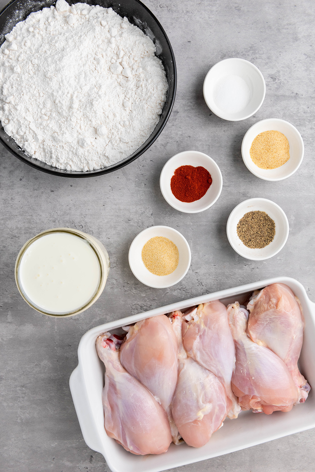 Ingredients for buttermilk fried chicken drumsticks, including chicken, flour, buttermilk, and spices.