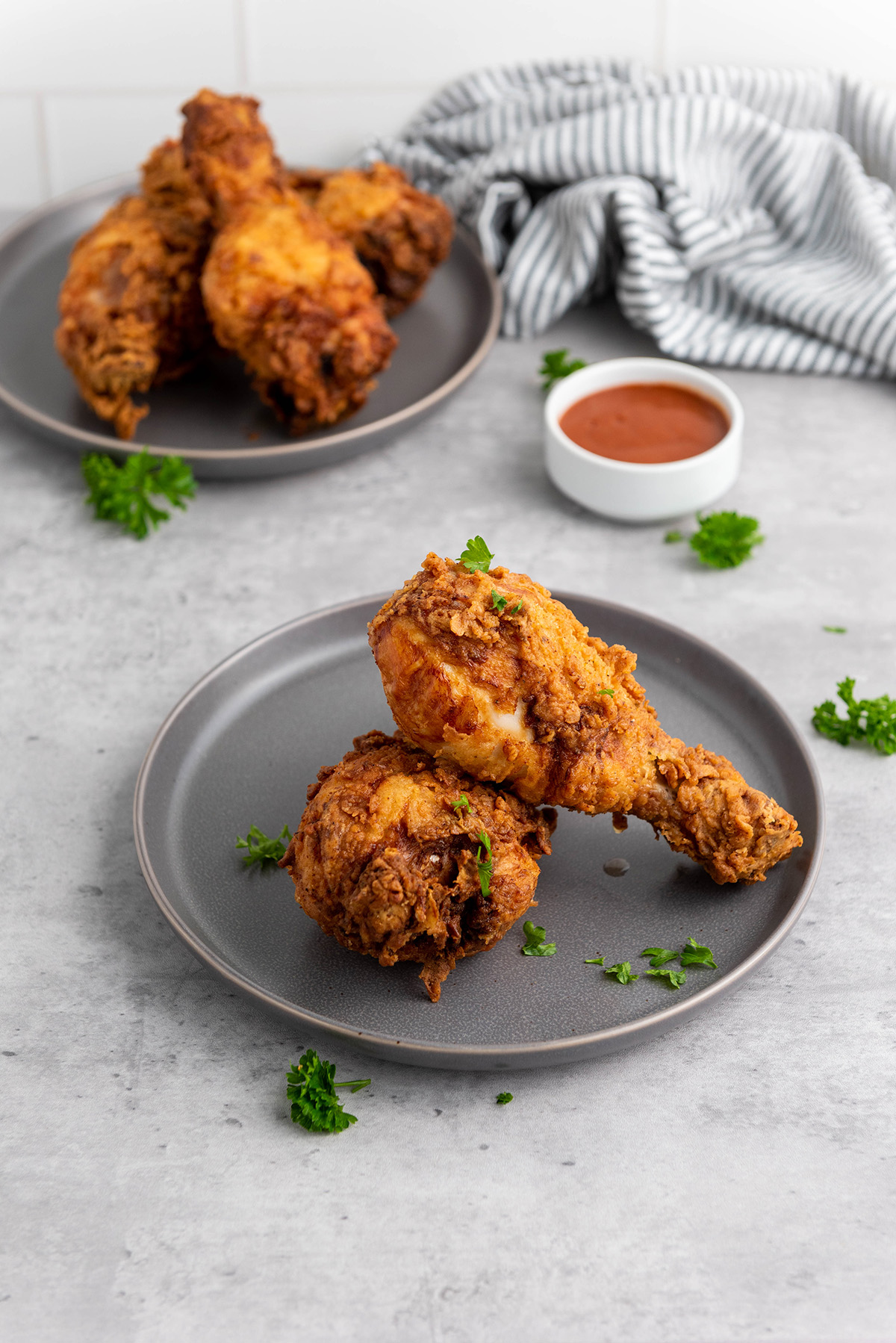 Two plate of buttermilk fried chicken with dipping sauce.