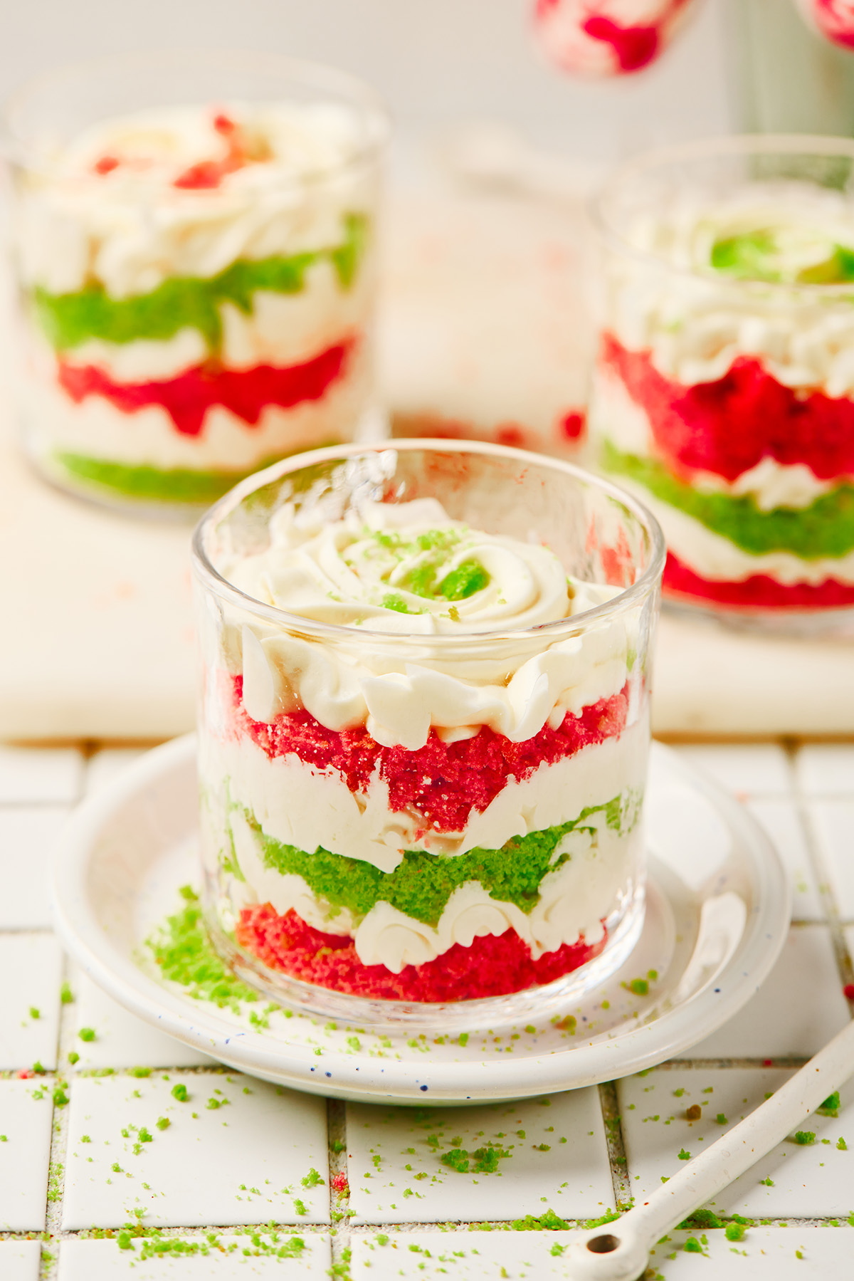 ndividual Christmas trifle dessert in a glass with bright red and green cake layers and cream.