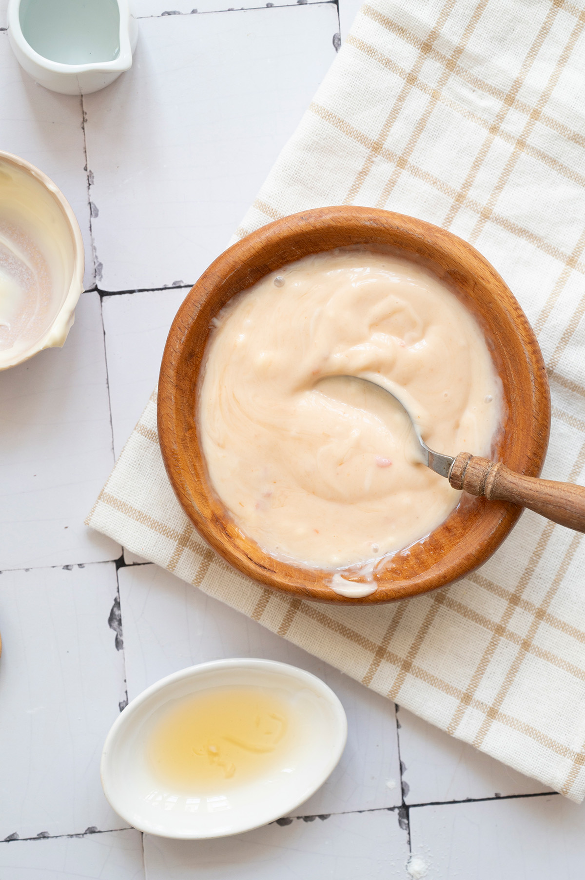 Bang bang sauce in a wooden bowl with a spoon, showing the creamy mixture made from mayo, sweet chili sauce, sriracha, honey, and rice vinegar.