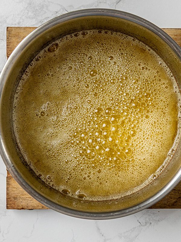 Melted butter bubbling in a saucepan as it browns and develops a nutty aroma.