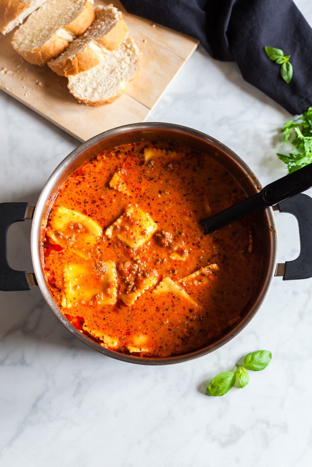 This million dollar ravioli soup is a cozy bowl of cheesy ravioli, rich tomato sauce, and tender ground beef. Simple ingredients come together in one pot, making it perfect for easy weeknight dinners. Creamy million dollar ravioli soup in a stockpot with a ladle, ready to serve with sliced bread.
