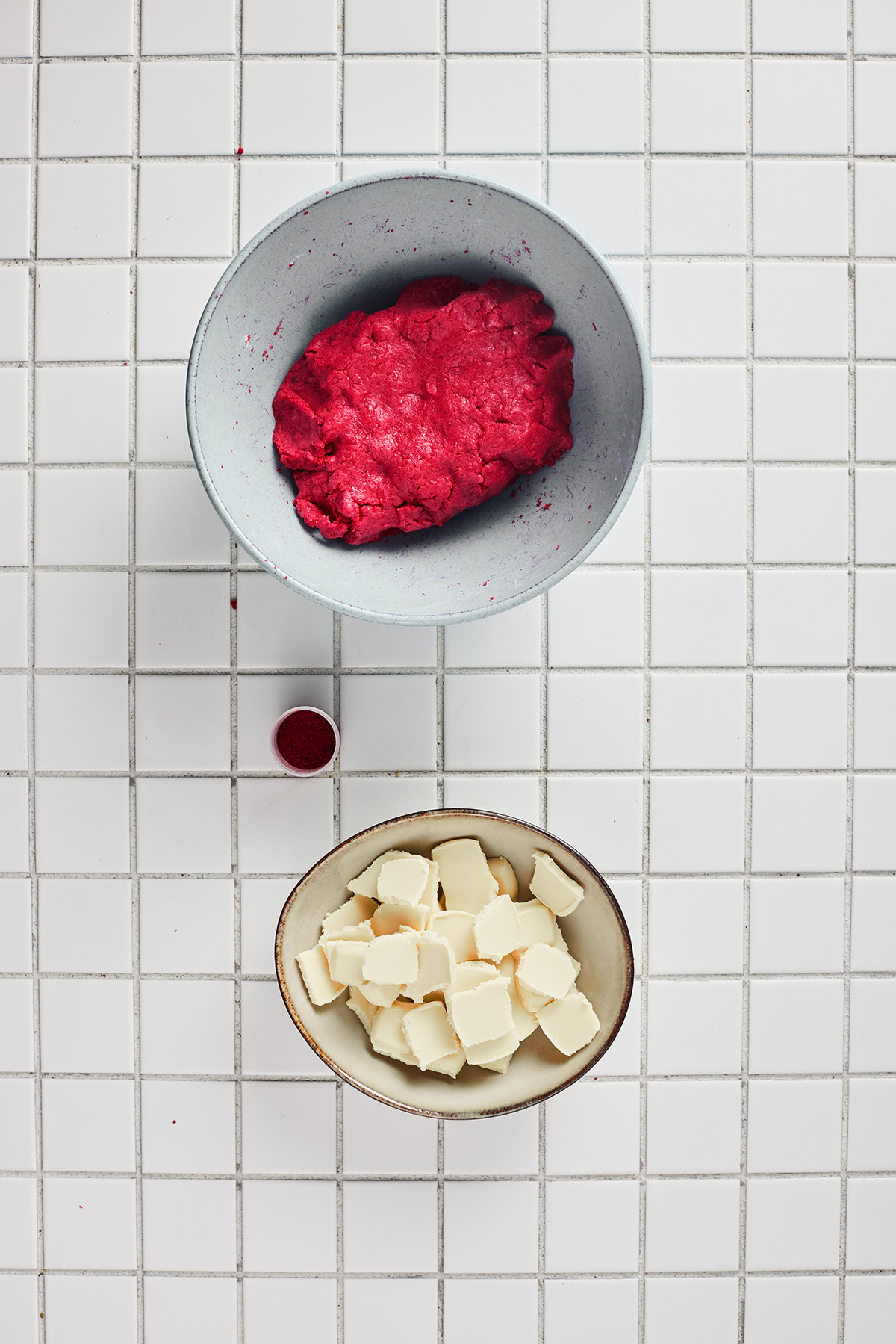 Red velvet cake and frosting mixed together into a soft dough in a large bowl.