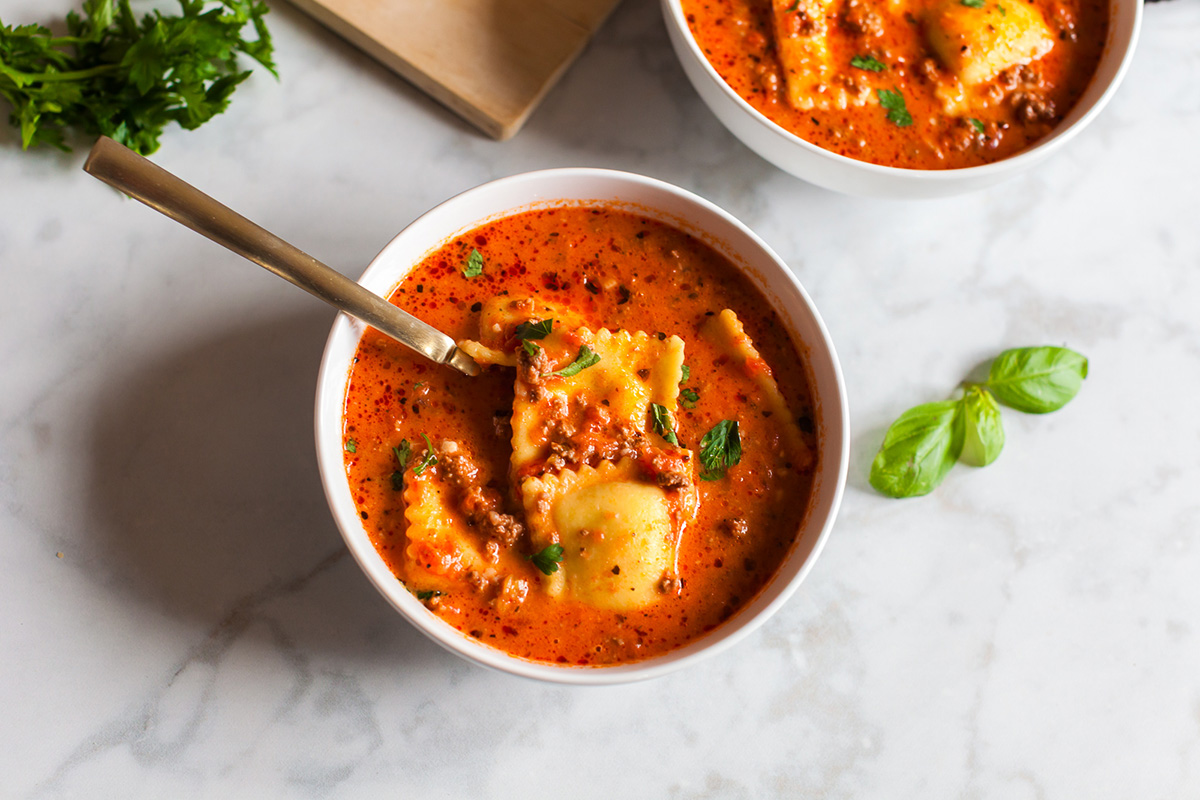 This million dollar ravioli soup is a cozy bowl of cheesy ravioli, rich tomato sauce, and tender ground beef. Simple ingredients come together in one pot, making it perfect for easy weeknight dinners. Bowl of million dollar ravioli soup with cheese ravioli, creamy tomato broth, ground beef, and fresh parsley on top.