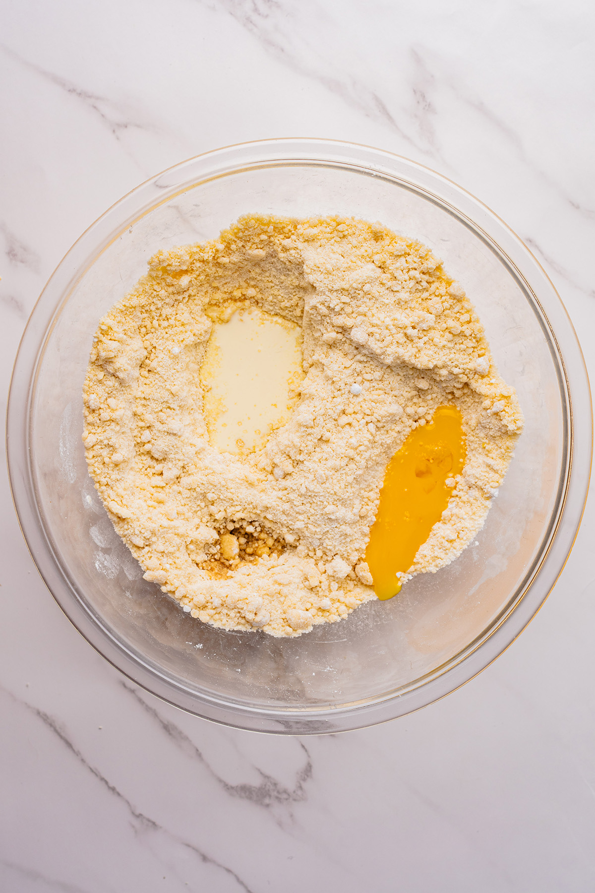 Flour mixture with heavy cream and egg yolk added to the center, ready to be mixed into dough for reindeer linzer cookies.