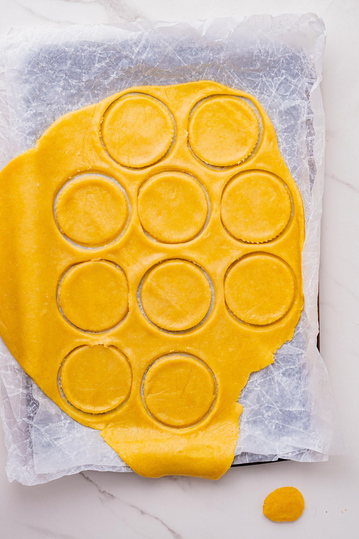 Rolled linzer cookie dough with evenly cut circles ready to become reindeer linzer cookies.