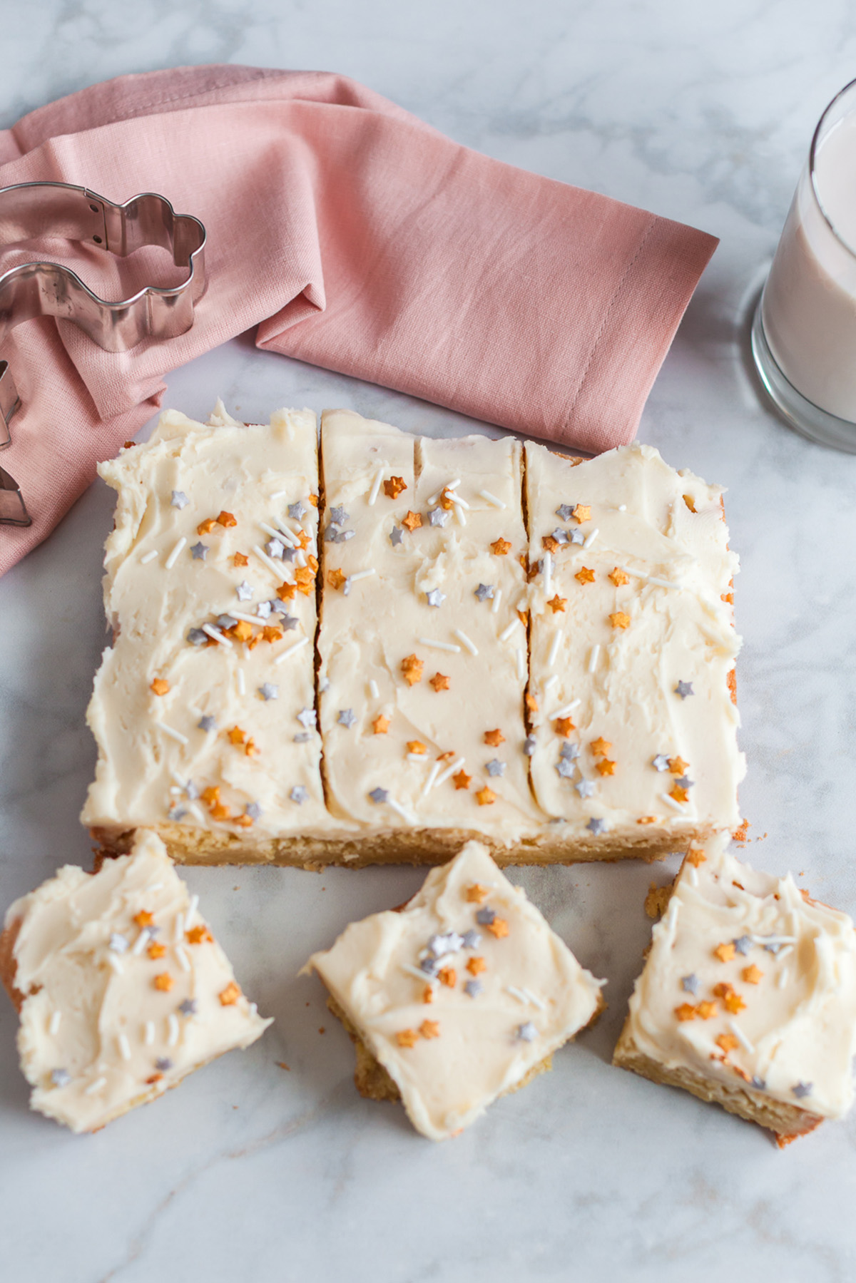 Betty Crocker sugar cookie bars lined up with creamy vanilla frosting and decorative sprinkles.