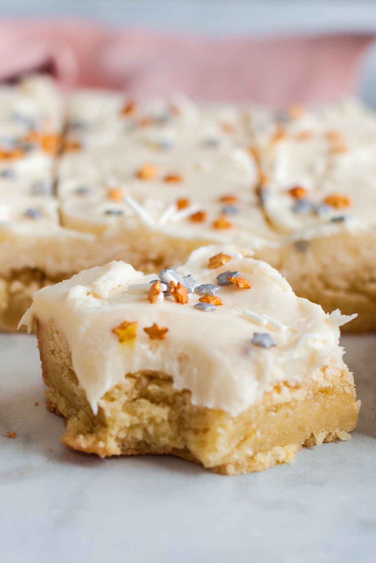 Close-up of a Betty Crocker sugar cookie bar topped with vanilla buttercream and star sprinkles.