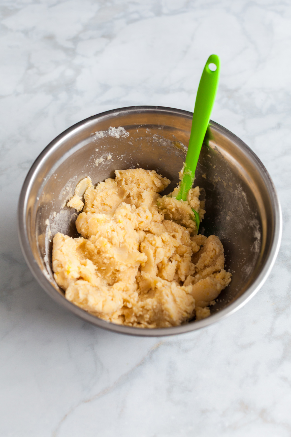 Betty Crocker sugar cookie bar dough mixed in a stainless steel bowl with a spatula.
