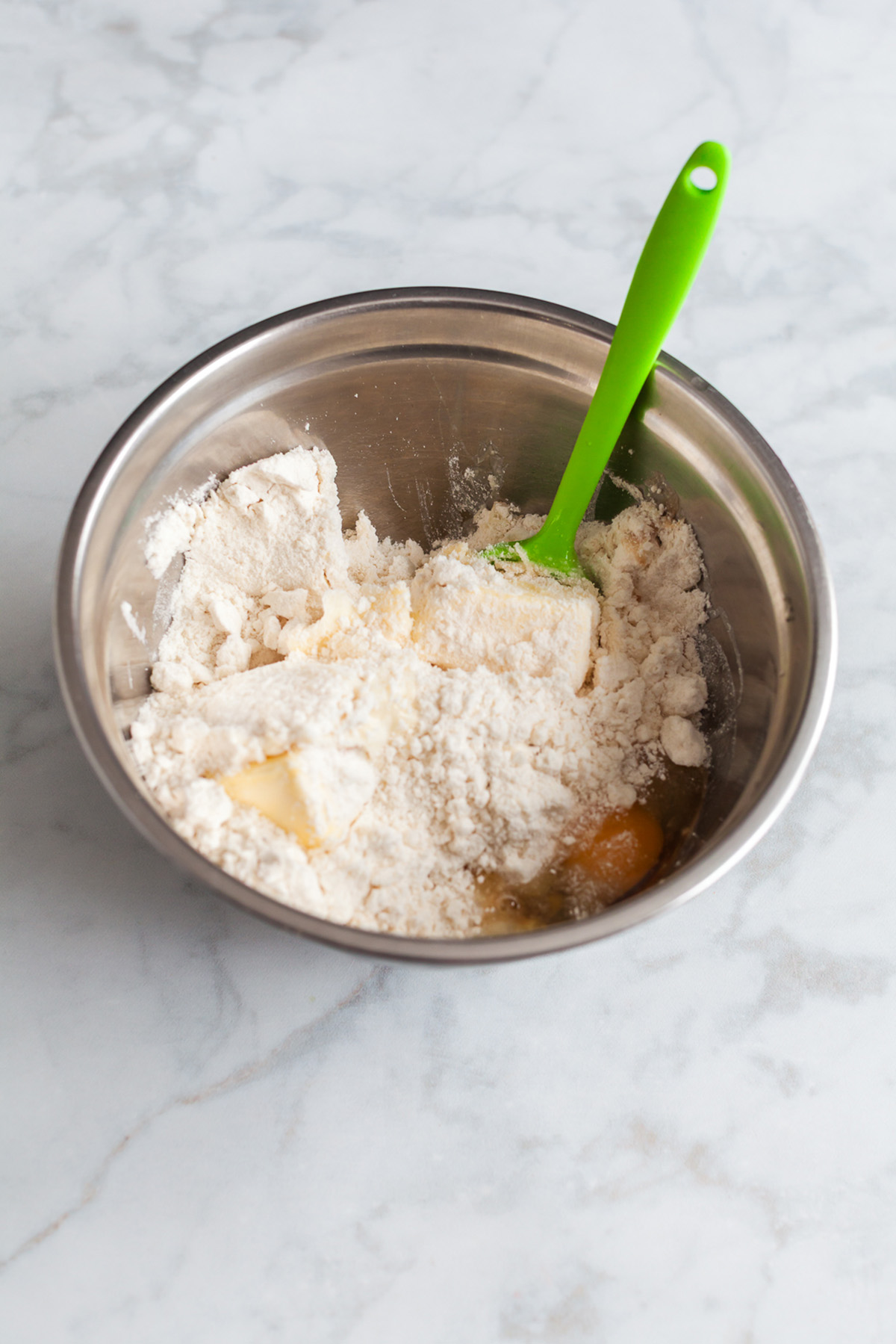 Betty Crocker sugar cookie mix, butter, egg, and egg yolk combined in a mixing bowl before stirring.