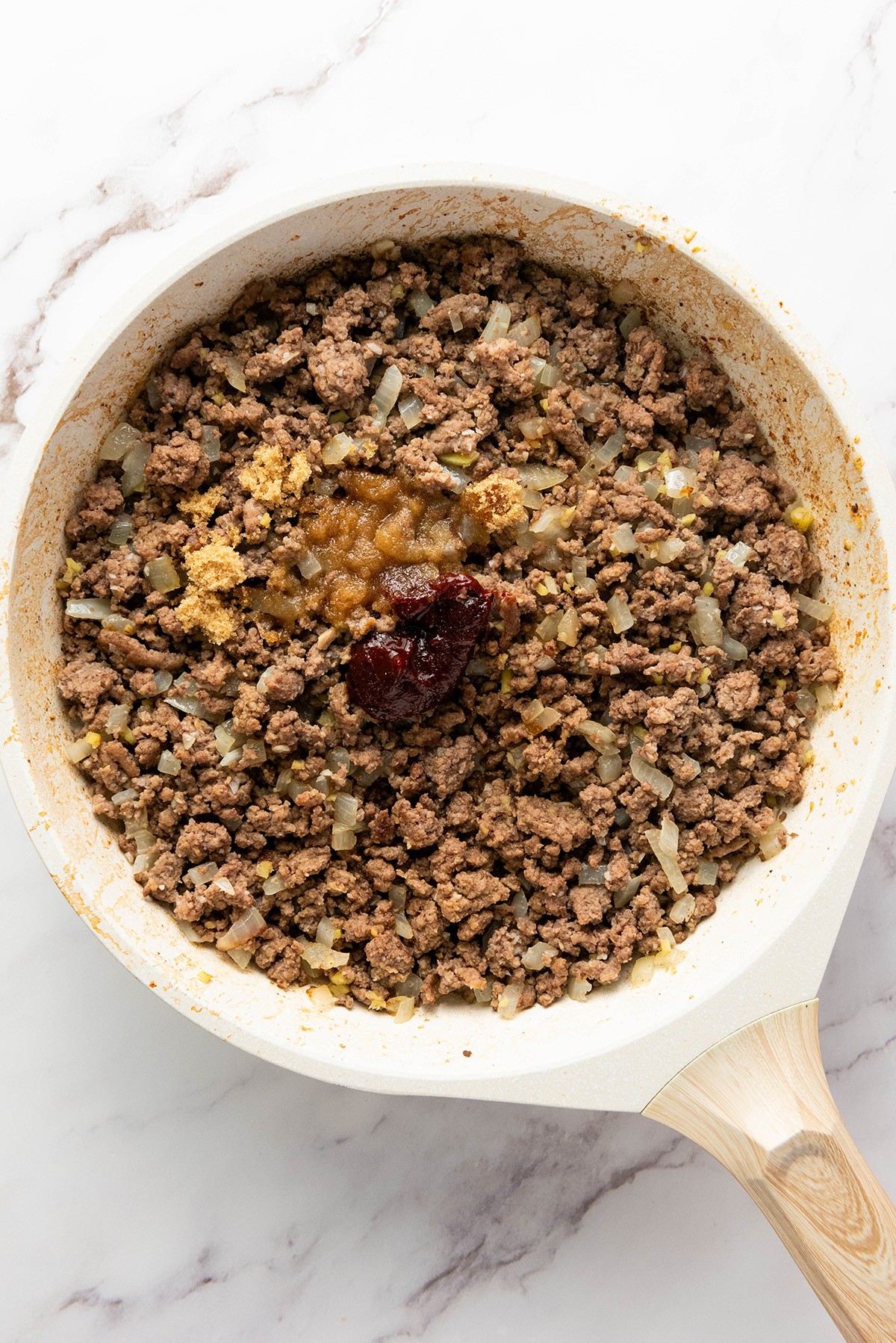 Gochujang sauce added to cooked ground beef with onions to create a savory Korean-style filling.
