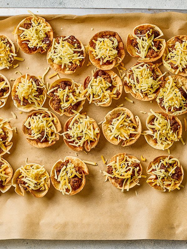 Shredded cheese added to taco ranch bites before baking in the oven.