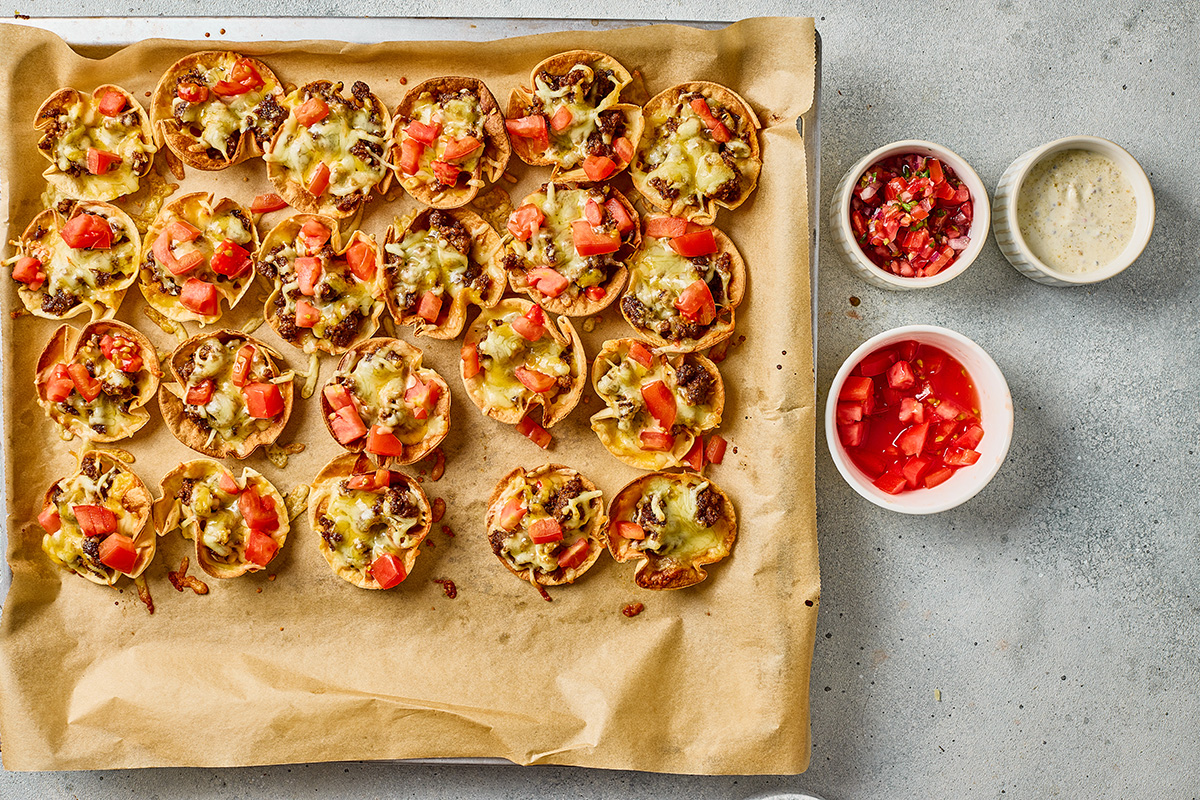 Baked taco ranch bites topped with diced tomatoes after the cheese has melted.