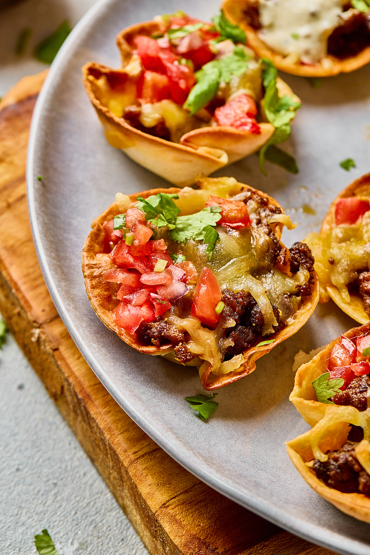 Finished taco ranch bites garnished with fresh cilantro and diced tomatoes on a serving plate.