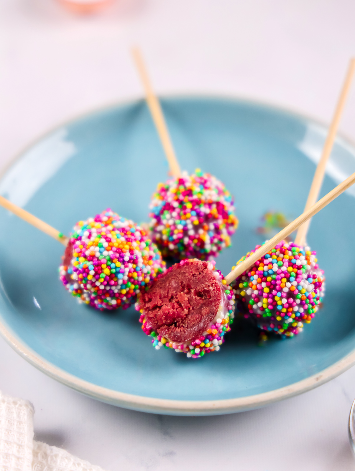 Red velvet cake pop cut open to show the soft, cake-like center.