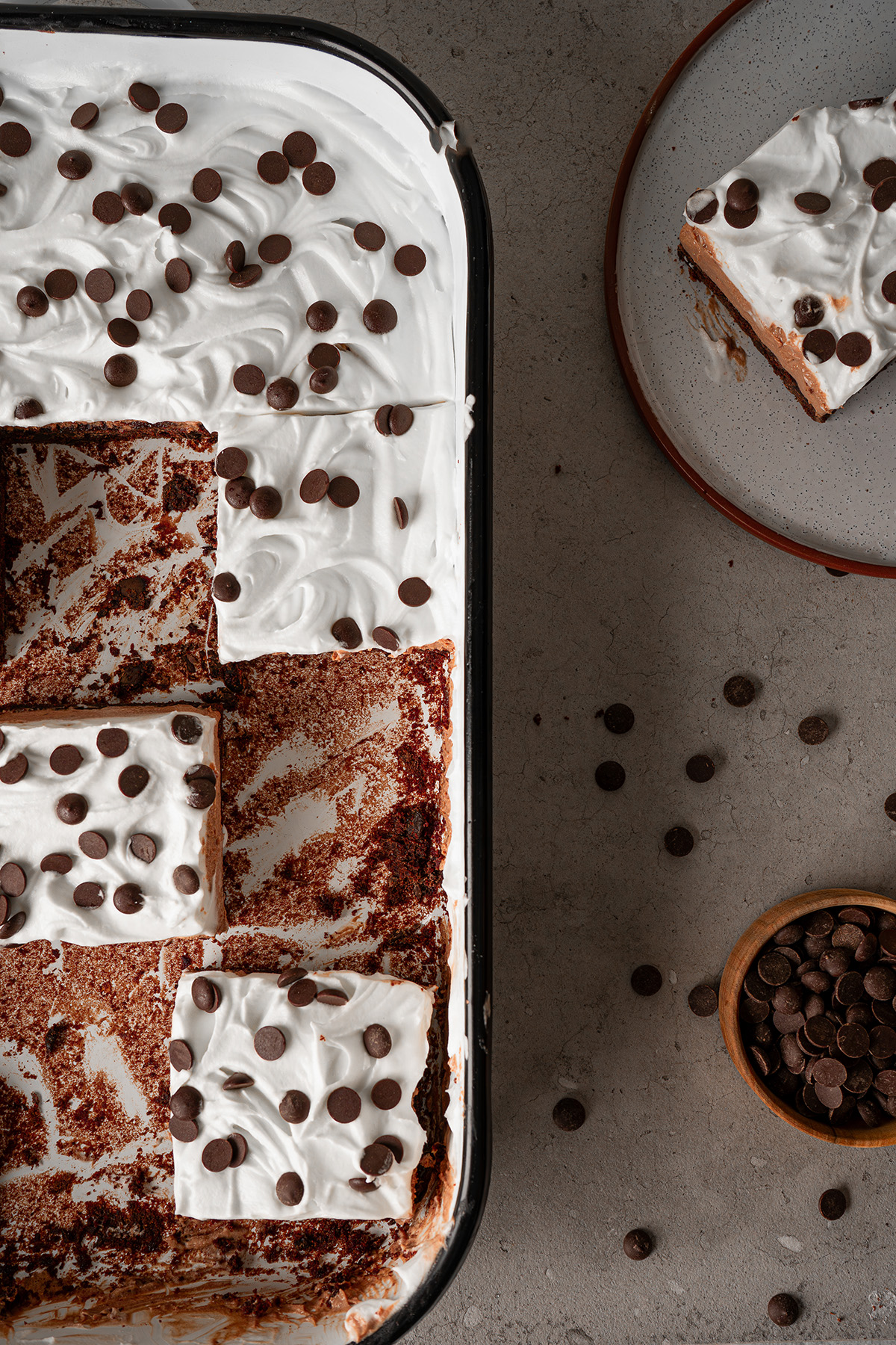 Overhead view of French silk brownies with brownie mix sliced in a baking dish and topped with whipped topping and chocolate chips.