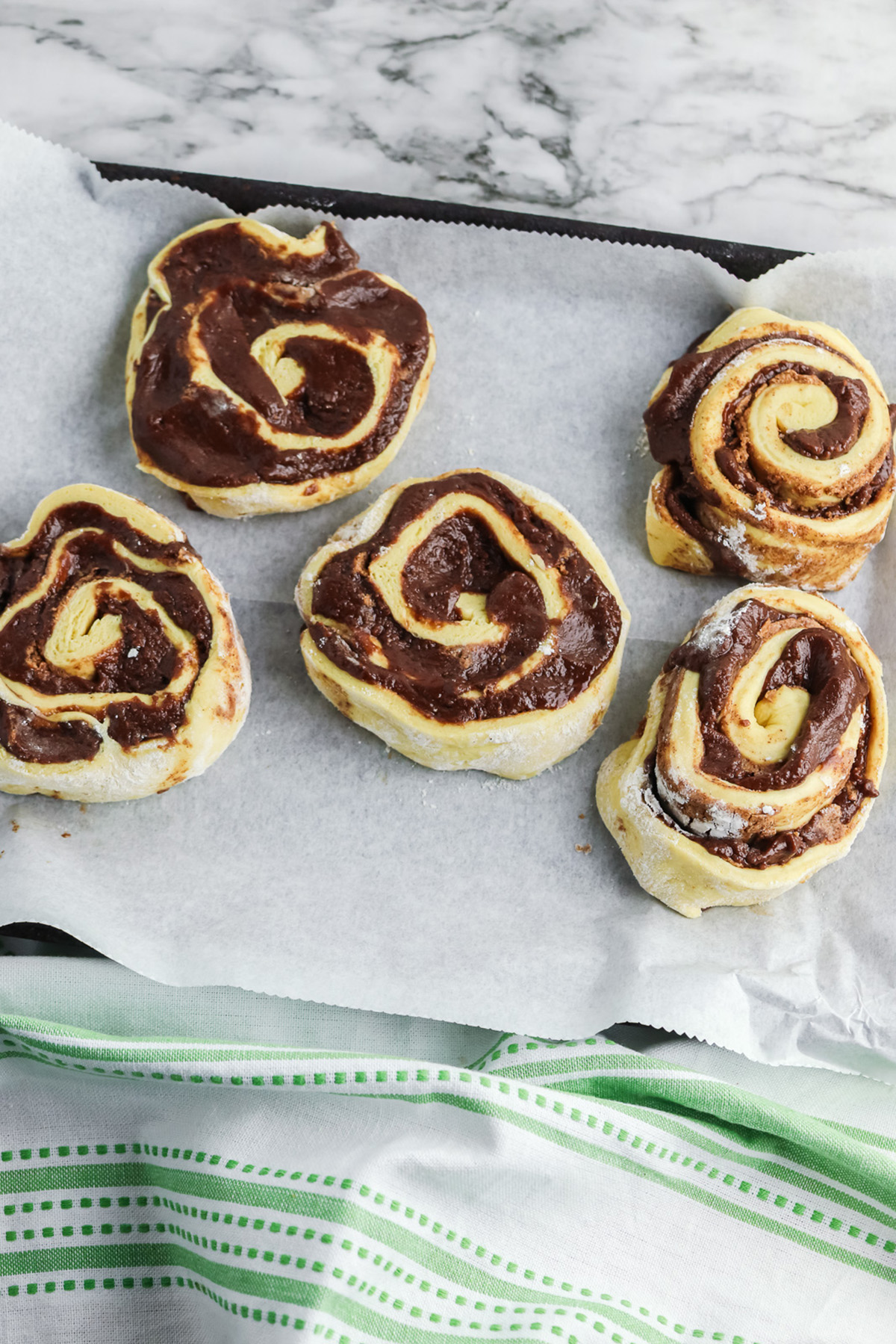 Unbaked brownie stuffed cinnamon rolls with chocolate brownie batter layered inside the swirls.