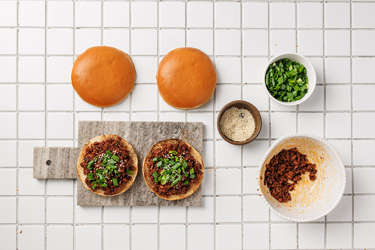 Korean sloppy joes topped with chopped green onions and sesame seeds on toasted brioche buns.