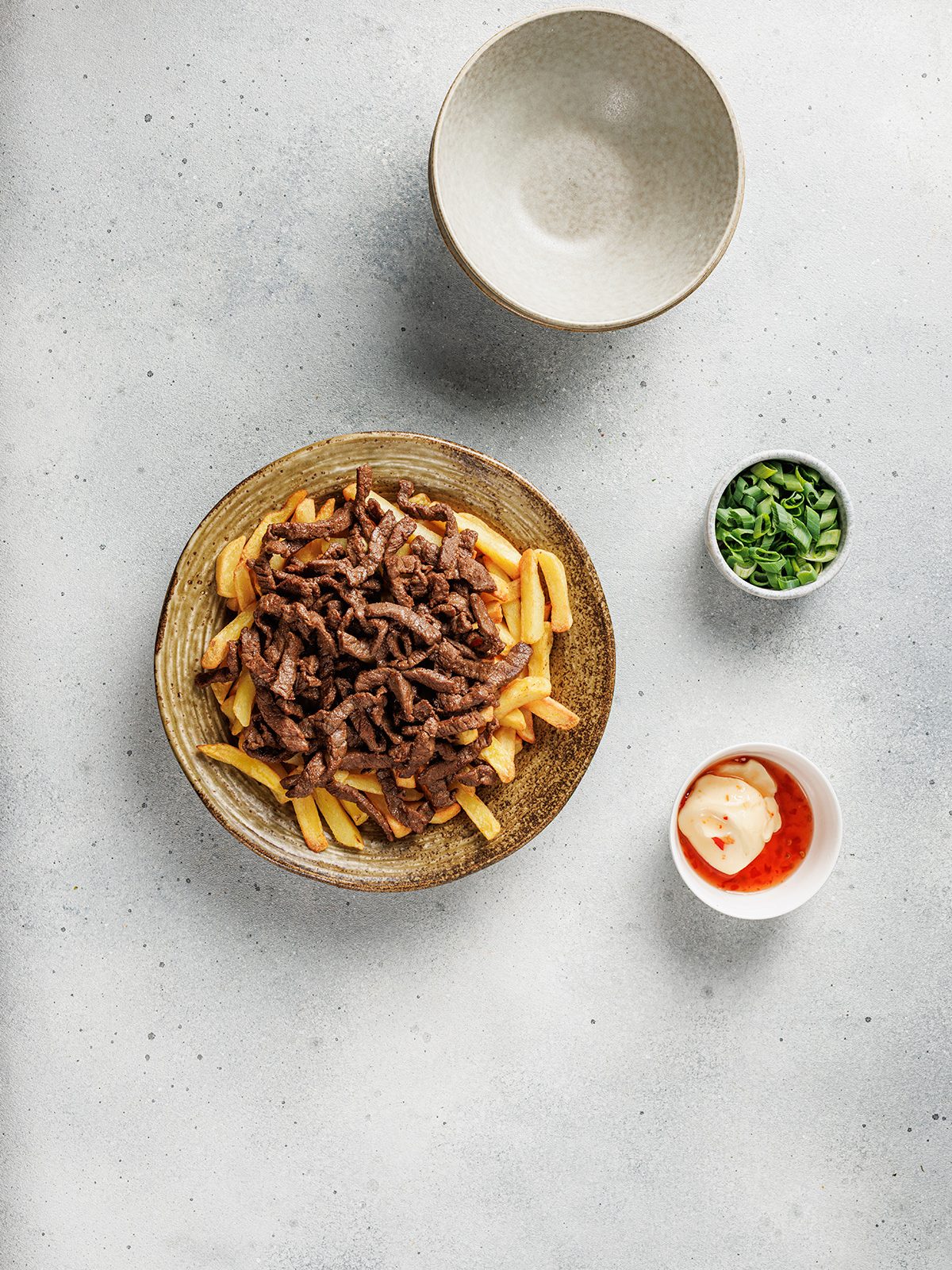 Korean-style loaded fries topped with saucy beef before adding spicy mayo.