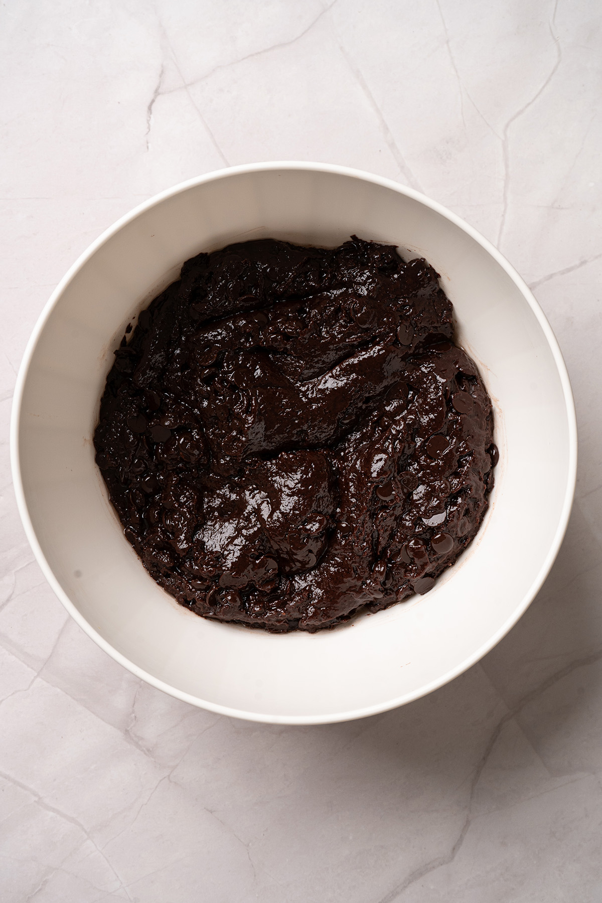 Thick chocolate brownie batter mixed with chocolate chips for chocolate peanut butter box brownies.
