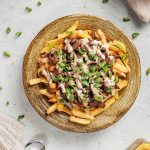 Overhead view of Korean-style loaded fries drizzled with spicy mayo.