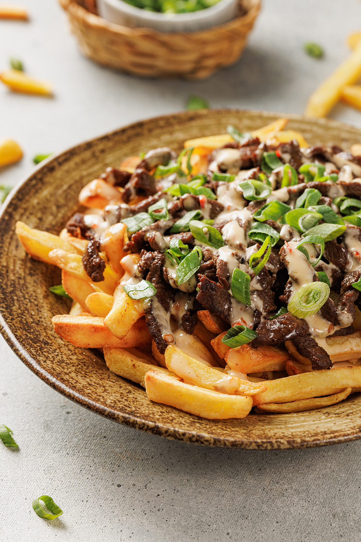 Korean loaded fries served in a bowl with tender beef and crispy fries.